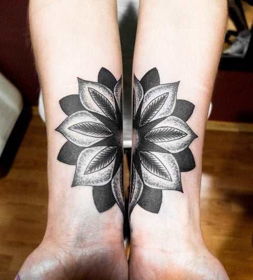 Tatuaje flor entre muñecas