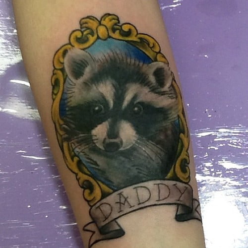 Tatuaje de mapache en brazo