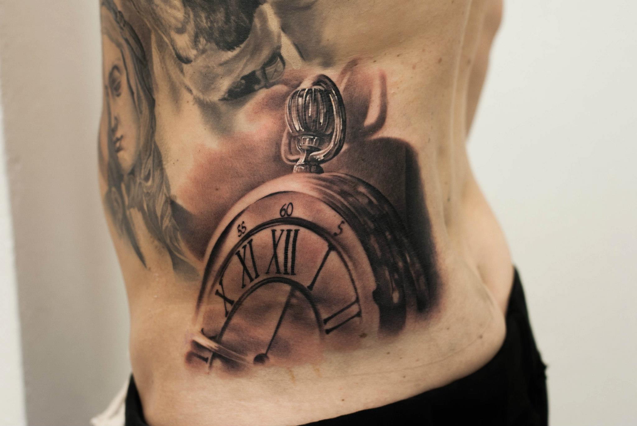 Tatuaje de un reloj de bolsillo en la cadera
