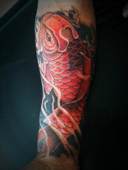 Carpa Koi tatuada en brazo