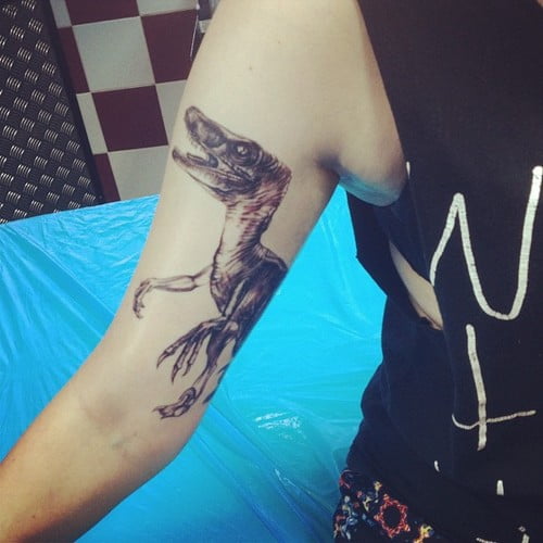 Velociraptor tatuado en el brazo