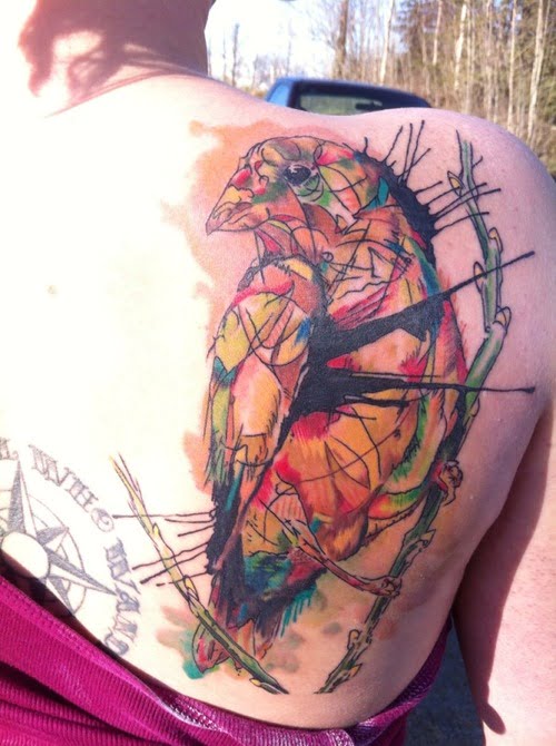 Tatuaje pájaro multicolor en la espalda
