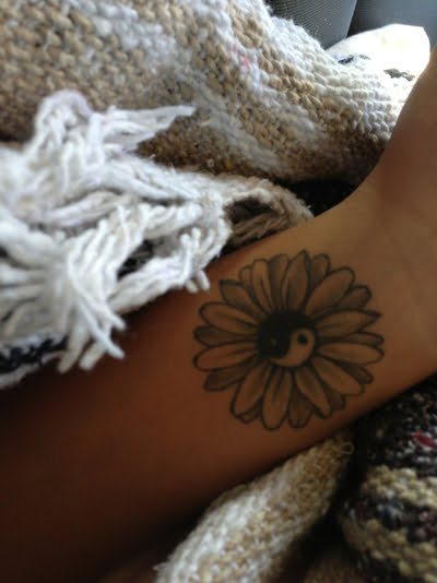 Tatuaje flor con Yin Yang en el brazo