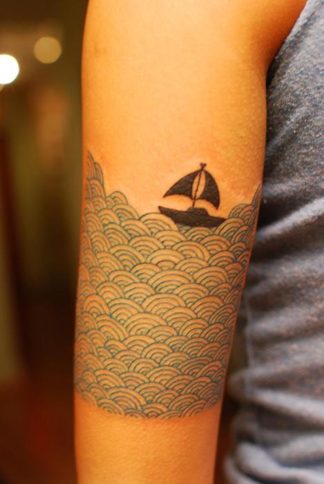 Tatuaje olas marinas en el brazo