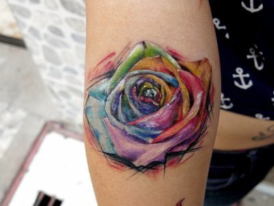 Tatuaje rosa multicolor en el antebrazo