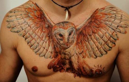 Tatuaje búho con las alas extendidas en el pecho