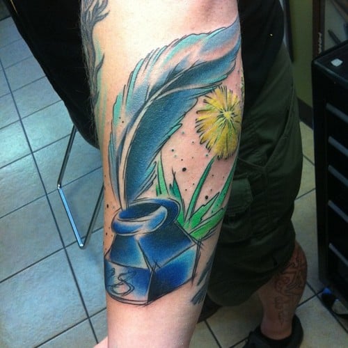 Tatuaje pluma y tintero en el brazo