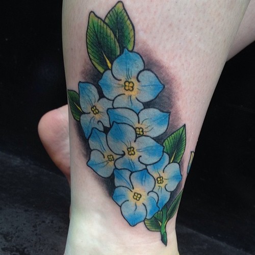 Tatuaje flores azules en la pierna