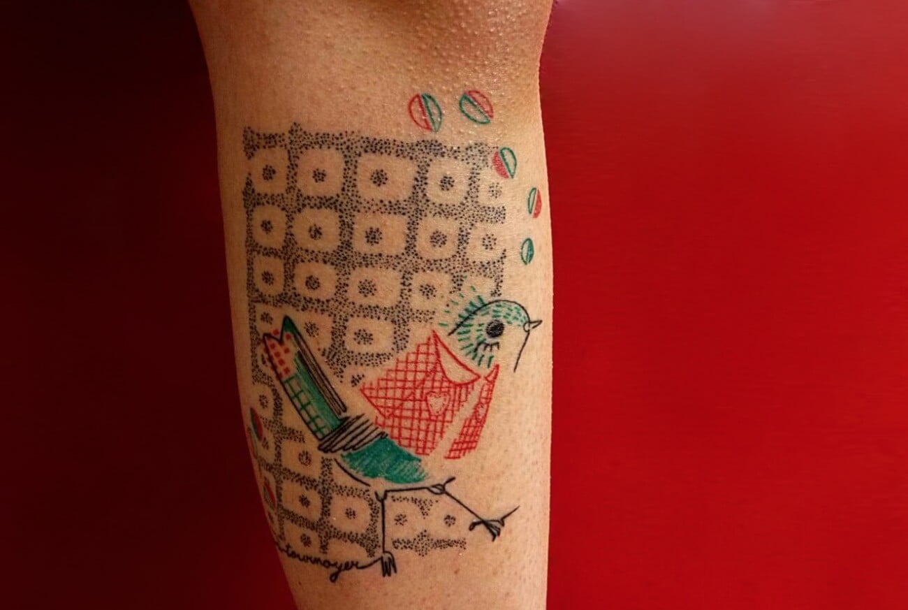 Tatuaje pájaro azul en la pierna