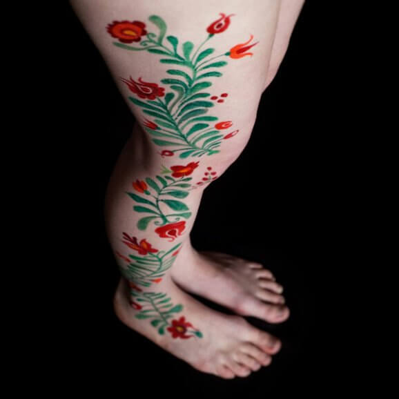 Tatuaje flores rojas en la pierna