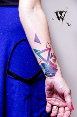 Tatuaje triángulos de colores en el brazo